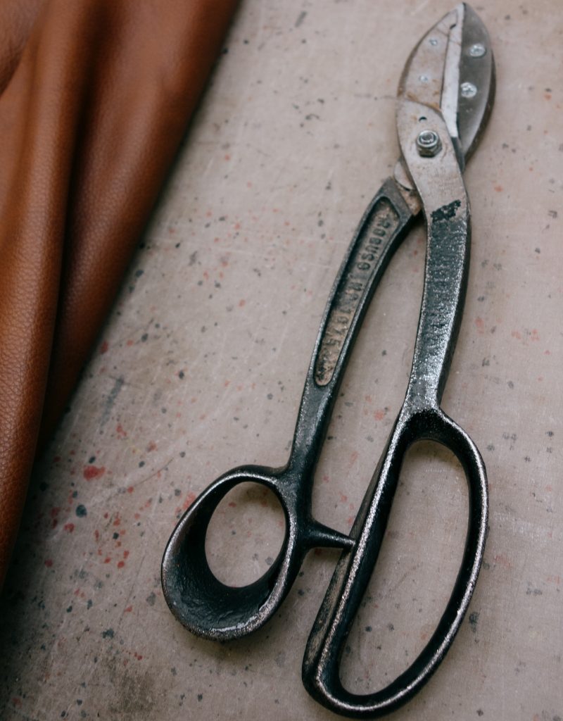 Detailaufnahme von Werkzeug neben einer Lederhaut in der Manufaktur